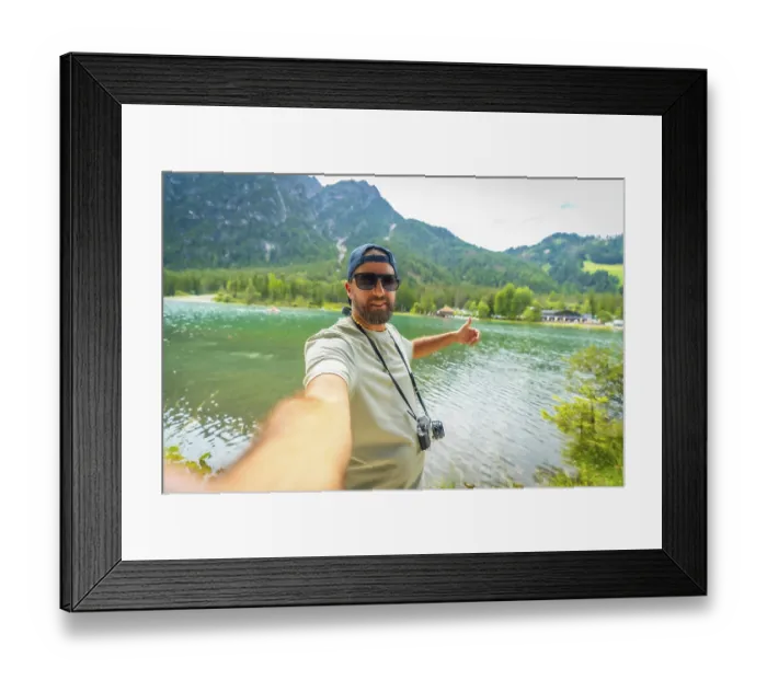 Framed Print : Tourist with vintage camera taking a selfie with thumbs up at lake dobbiaco in the italian dolomites during summer