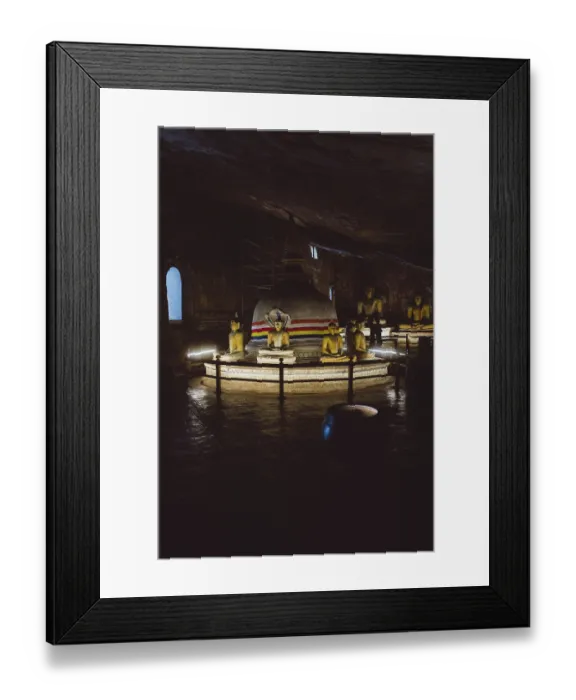 Framed Print : A stupa surrounded by Buddha statues in a dimly lit temple room