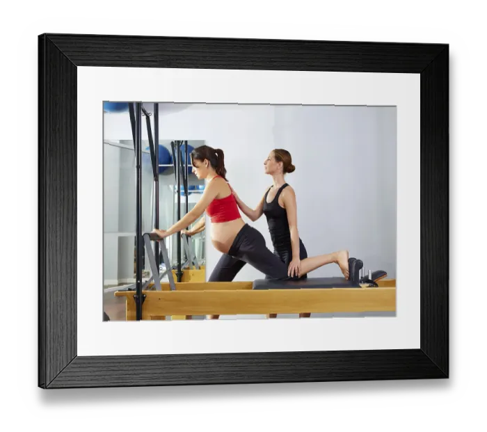 Framed Print : Pregnant woman pilates reformer cadillac exercise workout with personal trainer