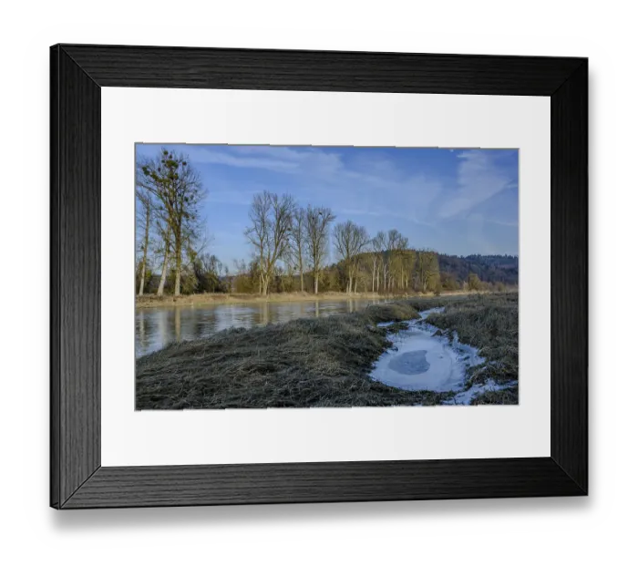 Framed Print : A wintry river flows near bare trees and hills Framed Print : A wintry river flows near bare trees and hills