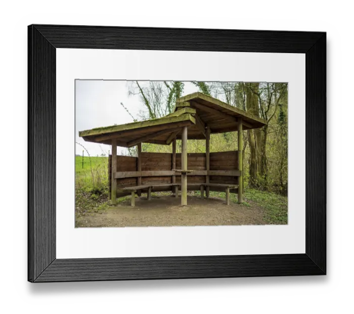 Framed Print : A rustic wooden shelter in the forest with benches Framed Print : A rustic wooden shelter in the forest with benches