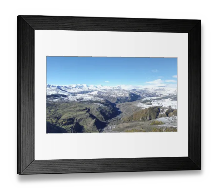 Framed Print : Snow-covered mountain range with a winding river and clear sky viewed from above