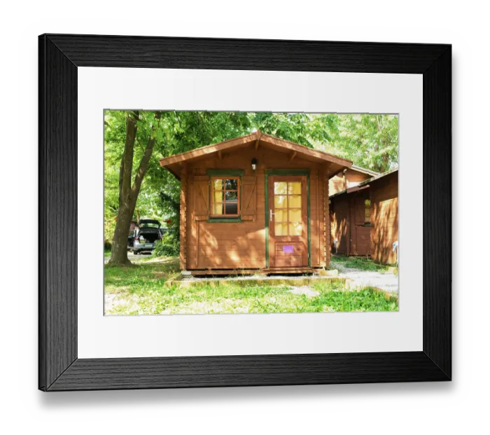 Framed Print : Wooden bungalows on campsite camping. Green trees
