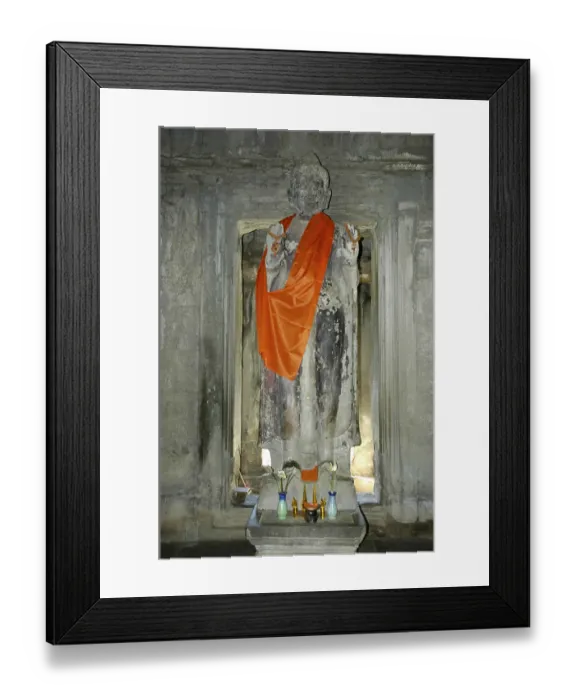 Framed Print : Old statue of a standing Buddha wearing an orange cape