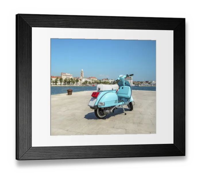 Framed Print : Blue vintage scooter stands on the waterfront on the background the city and the cruise ships in the sunny weather