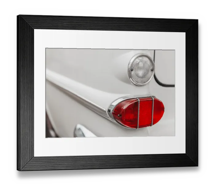 Framed Print : Left tail light with reversing light on a white vintage car with chrome trim