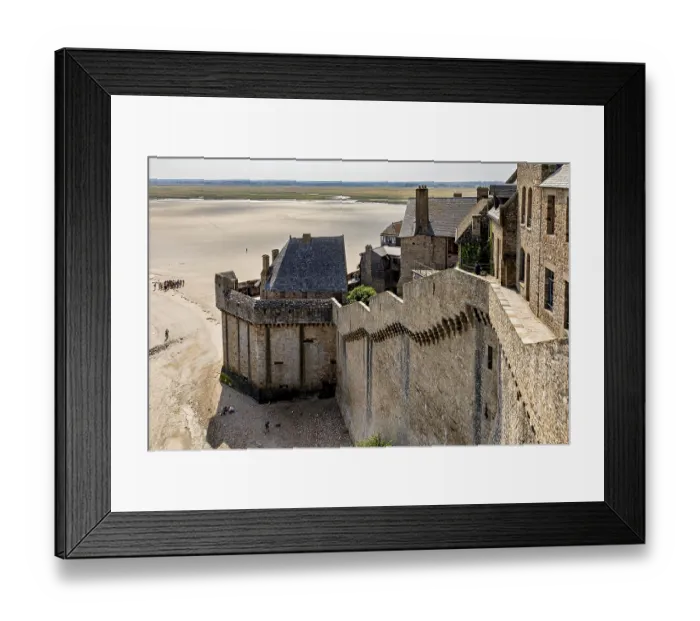 Framed Print : Historic castle wall with a view of a wide expanse of sand and distant buildings under a clear sky Framed Print : Historic castle wall with a view of a wide expanse of sand and distant buildings under a clear sky
