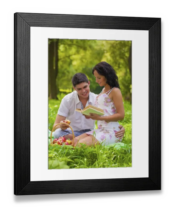 Framed Print : Young couple sitting on grass in park