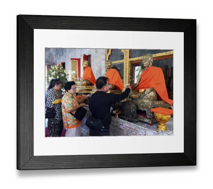 Framed Print : Believers cover statues of monks with gold leaf