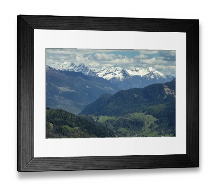 Framed Print : Beautiful aerial view of high snow-covered mountains and valley with village in Switzerland Framed Print : Beautiful aerial view of high snow-covered mountains and valley with village in Switzerland