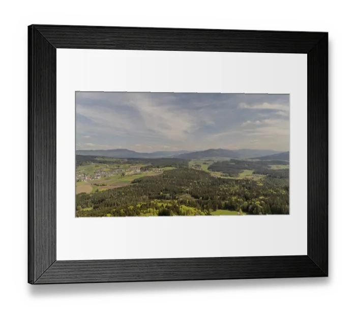 Framed Print : Expansive view of forest and mountains under a cloudy sky with diffuse sunlight