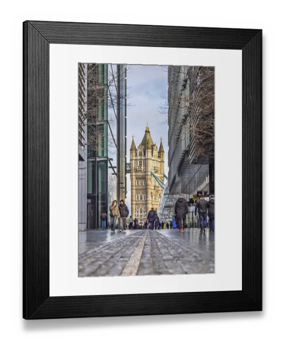 Framed Print : Tower Bridge zwischen modernen Glasgebauden auf einer KopfsteinpflasterstraBe Framed Print : Tower Bridge zwischen modernen Glasgebauden auf einer KopfsteinpflasterstraBe