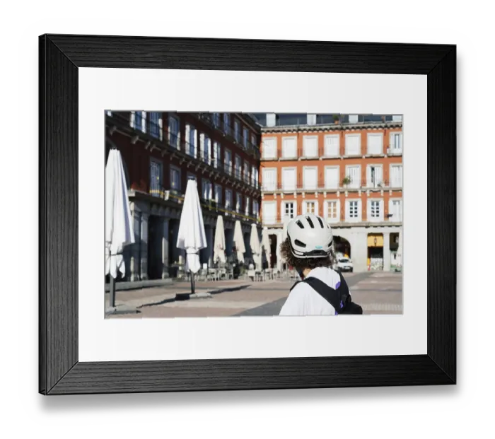 Framed Print : Unidentified female cyclist watching the closed terraces in Plaza Mayor of Madrid during coronavirus lockdown