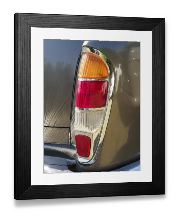 Framed Print : Detailed view of a tail light on a vintage car with chrome trim
