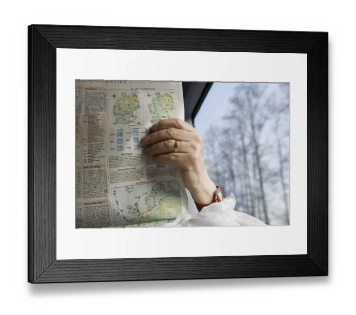 Framed Print : Old woman passenger reading newspaper in German rail journey