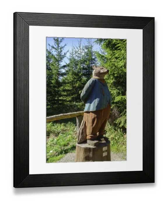 Framed Print : A wooden sculpture of a fox stands in the forest