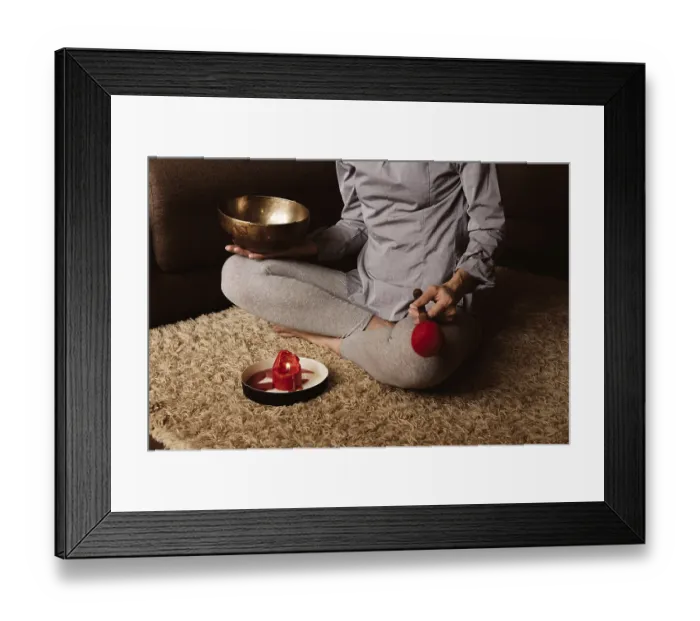 Framed Print : Faceless woman meditates at home on carpet and plays on copper singing bowl