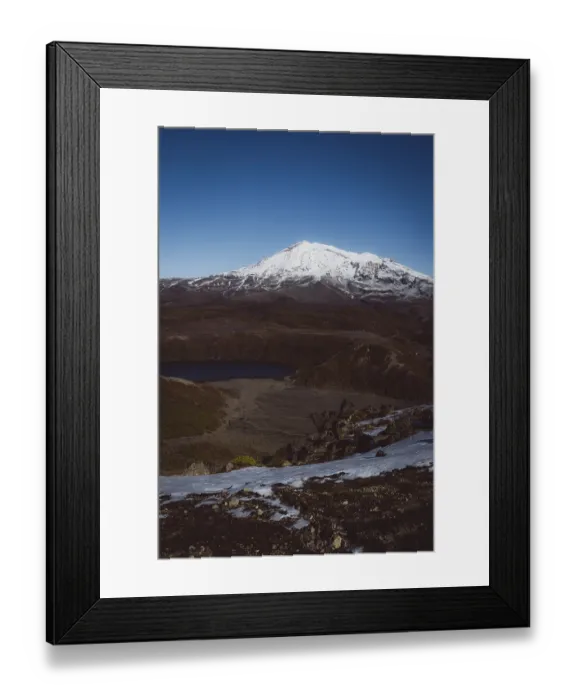 Framed Print : View of a snow-capped mountain and a lake in a rocky landscape under a blue sky