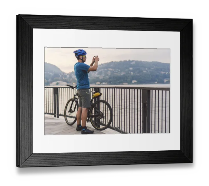 Framed Print : Cyclist taking pictures with smart phone