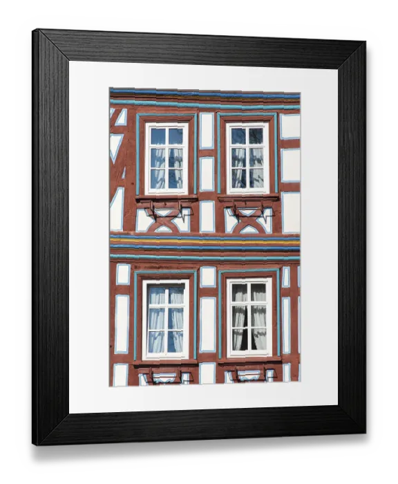 Framed Print : A restored and colourfully painted half-timbered facade with windows