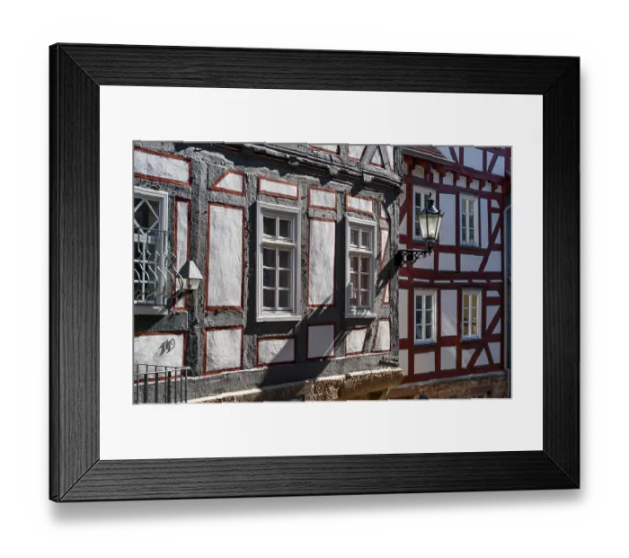 Framed Print : Oblique view of half-timbered houses with street lanterns with sunlight falling at an angle