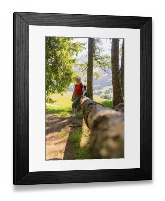 Framed Print : Woman leaning against a tree trunk