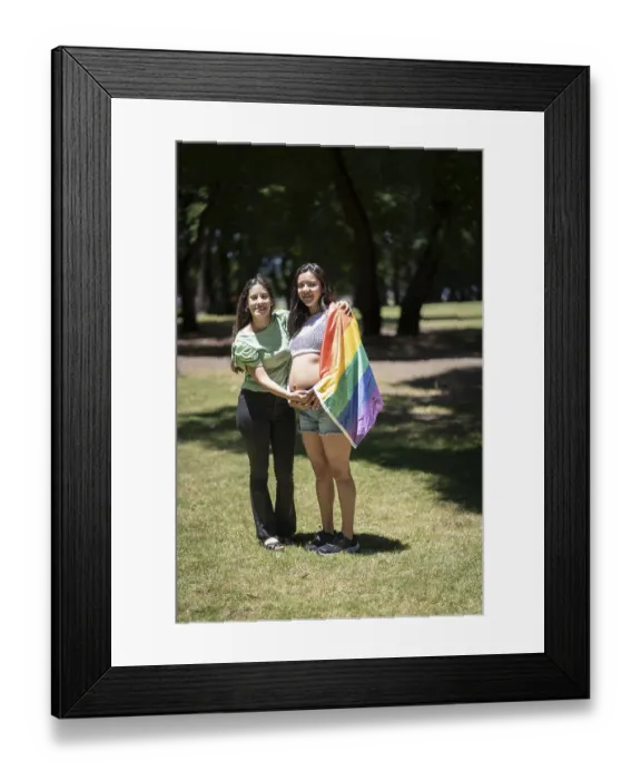Framed Print : Pregnant latin lesbian couple in a park with the LGBT flag