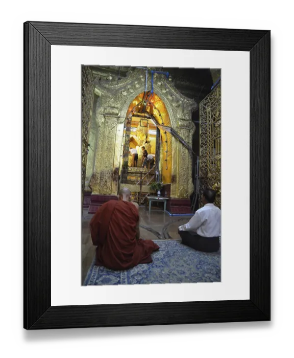 Framed Print : Burmese monk and a devout elderly man sitting in prayer in front of the most holy Buddha statue of the country