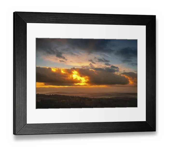 Framed Print : A Dramatic Sunset in the Evening with Clouds over a Valley in the Forest