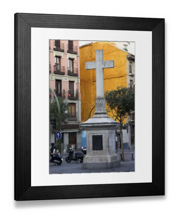 Framed Print : Stone cross made in 1738 against a vivid orange wall at the Plaza de Puerta Cerrada in the old part of Madrid in Spain