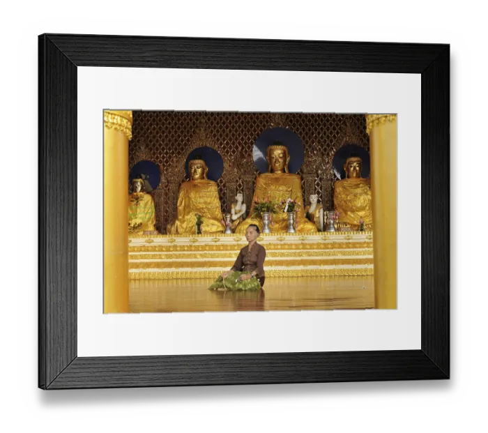Framed Print : Woman meditating in front of Buddha statues Framed Print : Woman meditating in front of Buddha statues
