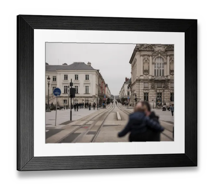 Framed Print : A street with tram tracks flanked by historic buildings and people walking in Tours