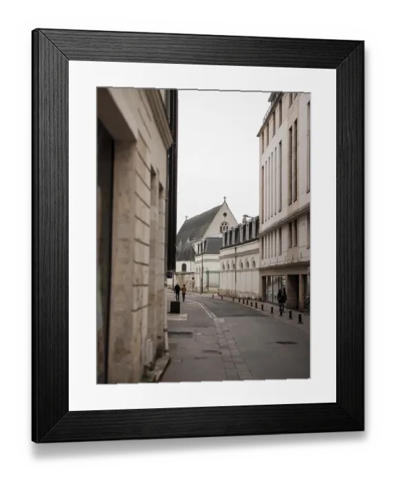 Framed Print : A quiet street lined with historic buildings leading to a church on an overcast day in Tours