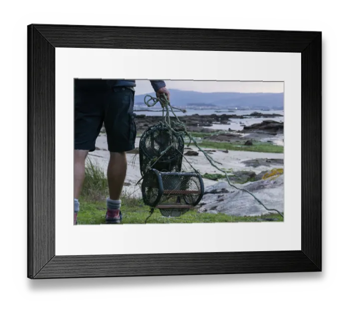Framed Print : A detail view of fisherman with crab traps walking to the beach at low tide to go to work