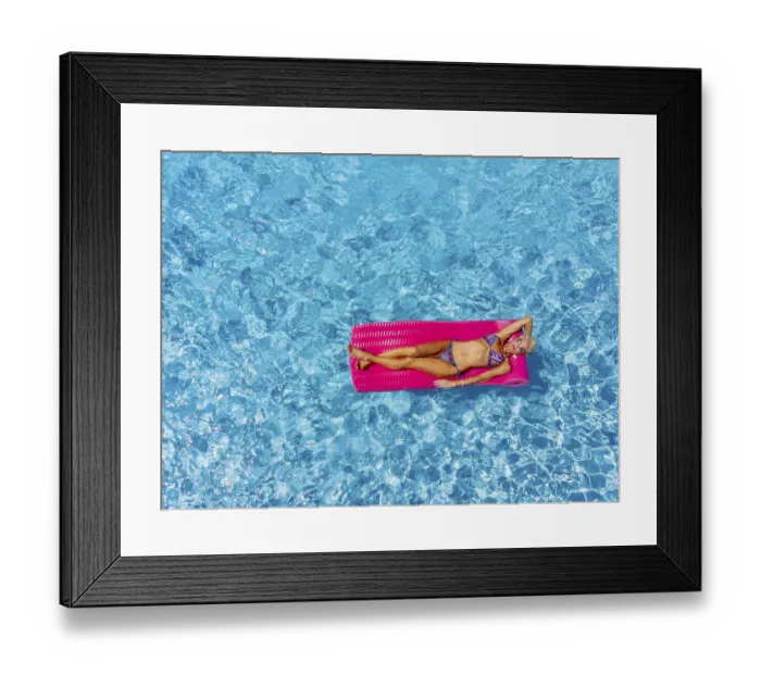 Framed Print : A beautiful mature blonde bikini model poses outdoors near a swimming pool