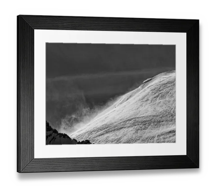 Framed Print : A snow-covered mountain in stormy conditions captured in a black and white image