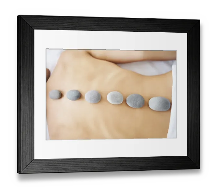 Framed Print : Cropped close up female relaxing in spa salon with hot stones on her back