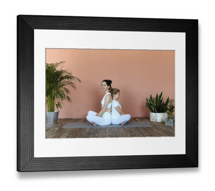 Framed Print : Smiling young woman and little girl practicing yoga on mat in cozy living room