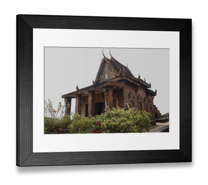 Framed Print : An ancient red brick temple with ornate carvings surrounded by lush greenery and flowers under a cloudy sky Framed Print : An ancient red brick temple with ornate carvings surrounded by lush greenery and flowers under a cloudy sky