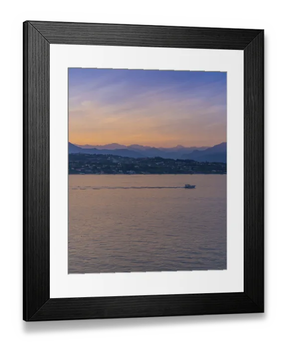 Framed Print : A boat in the sunset with the silhouettes of the mountains in the background on Lake Garda