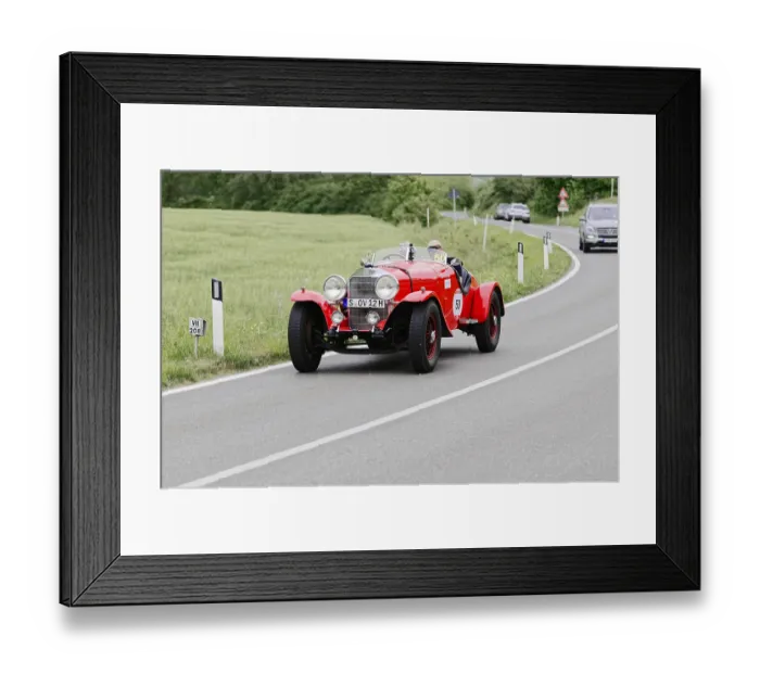 Framed Print : A red vintage racing car drives on a country road