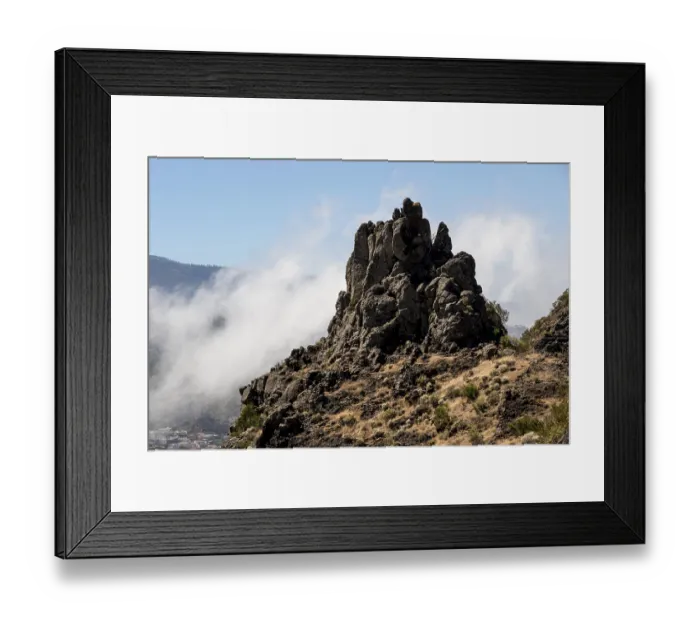 Framed Print : Rocky peak surrounded by clouds