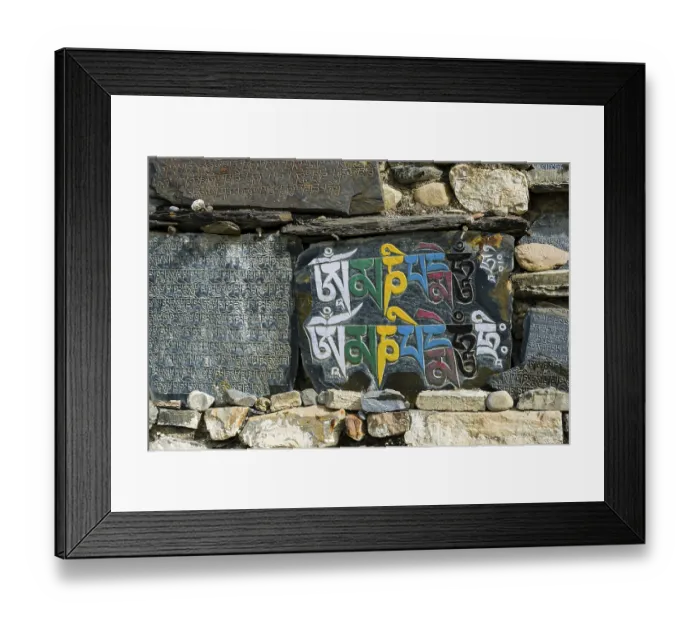 Framed Print : Mani stones with engraved colorful tibetan mantra at a wall