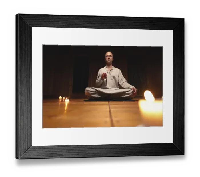 Framed Print : A man in clothes for practice and meditation sits in a lotus pose