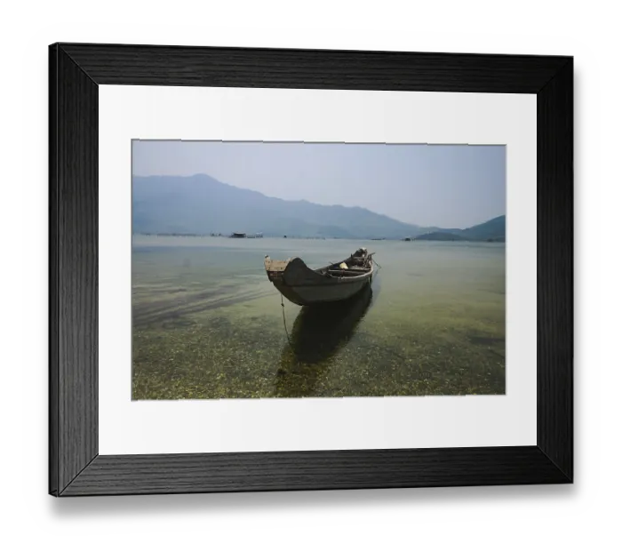 Framed Print : A solitary boat on still water with a clear mountain view Framed Print : A solitary boat on still water with a clear mountain view
