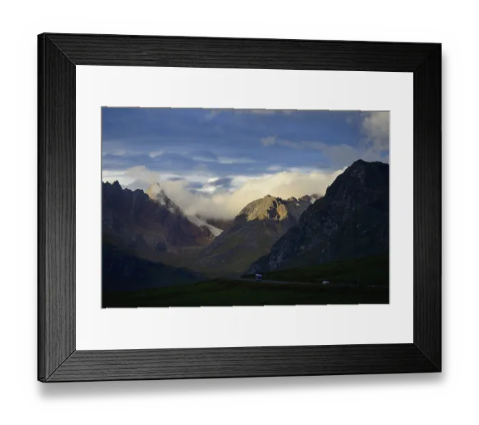 Framed Print : Evening sun on the mountains above the winding mountain road