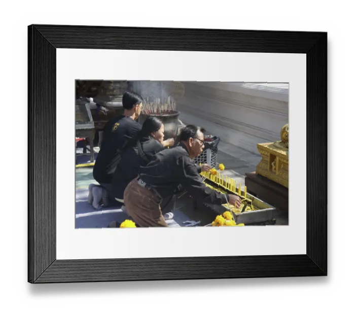 Framed Print : Three kneeling Buddhists with candles and incense