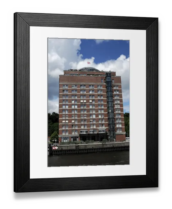 Framed Print : Modern hotel building on a riverside with blue sky and clouds