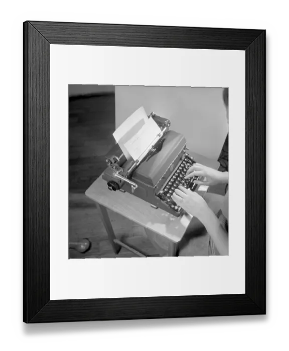 Framed Print : Office girl in the 1950s. A woman is sitting at a office desk typing on her typewriter Framed Print : Office girl in the 1950s. A woman is sitting at a office desk typing on her typewriter