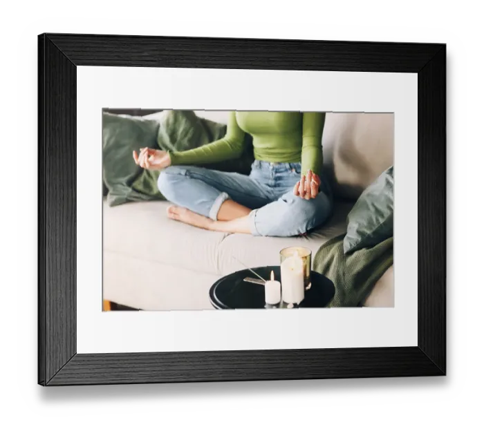Framed Print : Unrecognizable barefoot woman sitting on bed in Lotus pose and meditating during yoga session at home